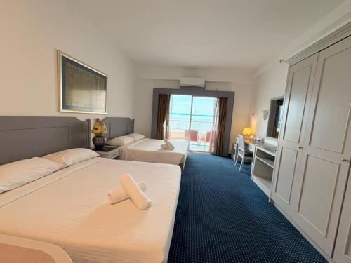 a hotel room with two beds with a cross on them at Rainbow Paradise Seaview by Achlys Collection in Tanjung Bungah