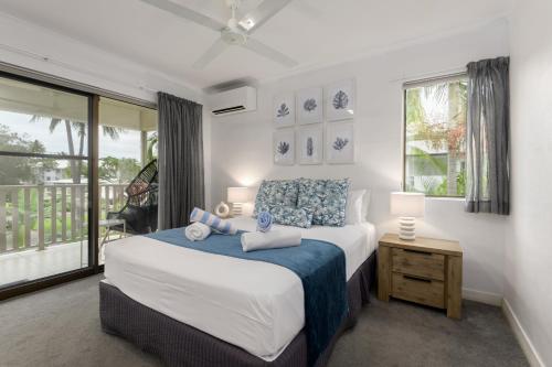a bedroom with a large bed and a window at Seascape Holidays - Tropical Reef Apartments in Port Douglas