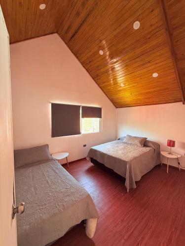 a bedroom with two beds and a flat screen tv at Villa Doña Isabel in Lunahuaná
