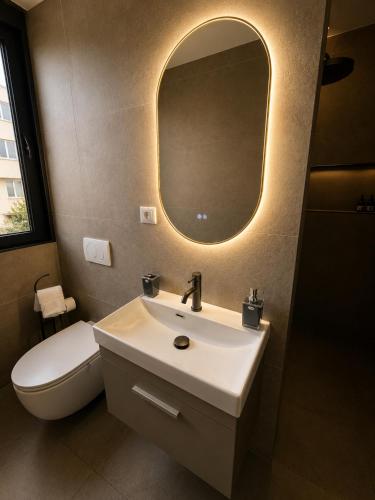 a bathroom with a sink and a toilet and a mirror at Bedo Boutique Hotel in Golem