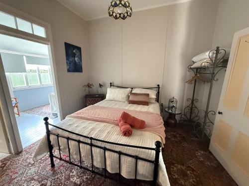 a bedroom with a bed with pink sheets and a chandelier at Finney Cottage in Stanthorpe