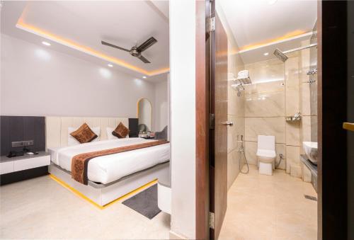 a bedroom with a bed and a bathroom with a shower at Hotel Maharani Palace in Varanasi