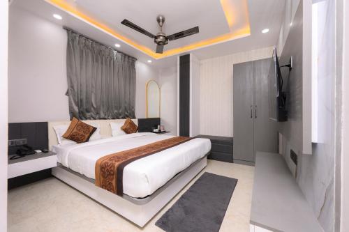 a bedroom with a large bed and a tv at Hotel Maharani Palace in Varanasi