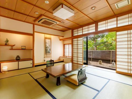 a dining room with a table and chairs and a large window at Suwa Grand Shrine Kameya Inn in Shimo-suwa