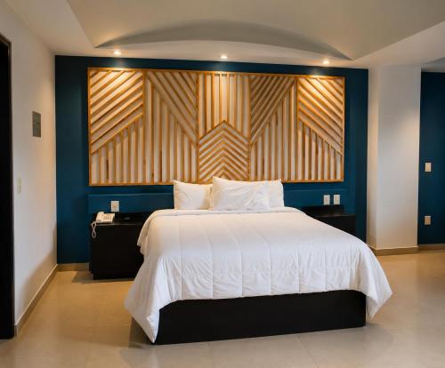 a bedroom with a large bed and a blue wall at Hotel Borda Cuernavaca in Cuernavaca
