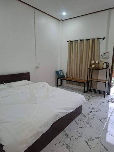 a bedroom with a large white bed with marble floors at Sokmoungkhoun in Nongkhiaw