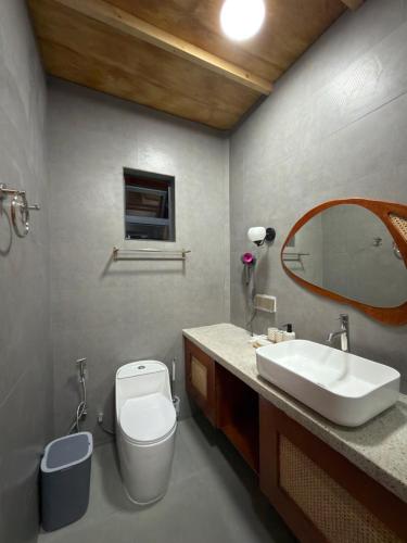 a bathroom with a sink and a toilet and a mirror at HB'S iSLAND LiFE in Mathiveri