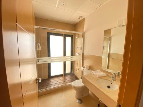 a bathroom with a toilet and a sink and a window at Casa Corner- Bonito Apartamento con mini piscina en Hacienda del Alamo in Escobar