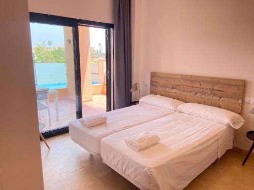 a bedroom with a bed with two towels on it at Casa Corner- Bonito Apartamento con mini piscina en Hacienda del Alamo in Escobar