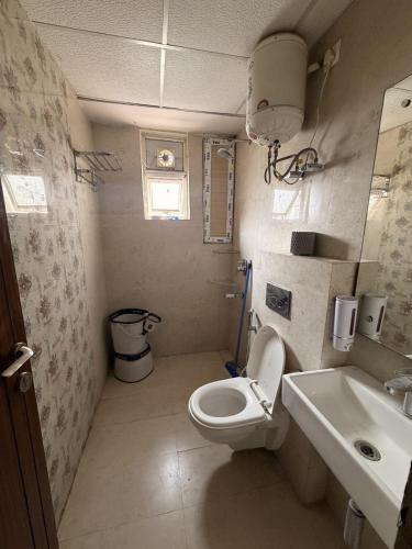 a small bathroom with a toilet and a sink at Rabbit Stays apartment in Zirakpur
