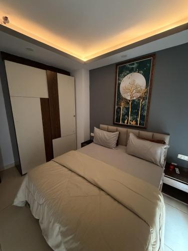 a bedroom with a large bed with a painting on the wall at Rabbit Stays apartment in Zirakpur