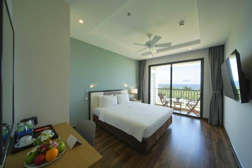 a hotel room with a bed and a table with a plate of fruit at Wyndham Garden Grandworld Phu Quoc in Phú Quốc