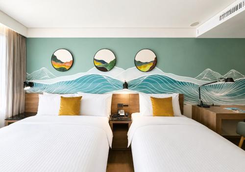 two beds in a room with mirrors on the wall at Just Sleep Hualien ZhongZheng in Hualien City