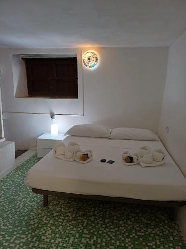 a bedroom with a bed with towels and a window at Il Casale Apartament&Rooms in Burgio