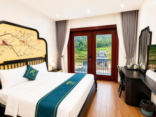 a bedroom with a bed and a desk and a window at Son Tinh Hotel in Dồng Văn