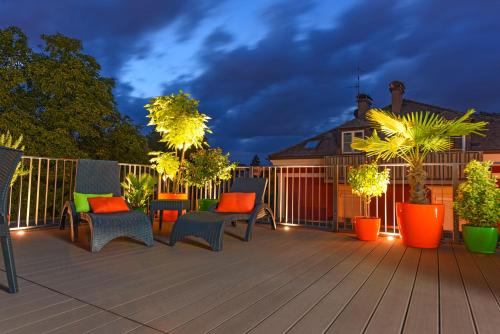 a deck with chairs and trees and a fence at Villa Salzburg by Welcome to Salzburg in Salzburg