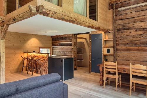 a living room with a blue couch and wooden walls at Chalet Nufenen in Ulrichen