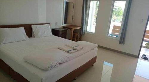 a bedroom with a bed with two towels on it at Prakaithong hotel in Amphoe Sawang Daen Din