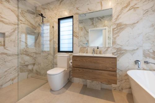 a bathroom with a toilet and a sink and a mirror at Valley Retreat in Smiths Lake