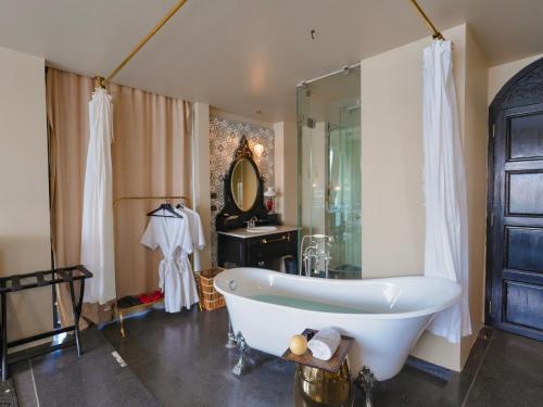 a bathroom with a bath tub and a sink at Amdaeng Bangkok Riverside Hotel in Bangkok