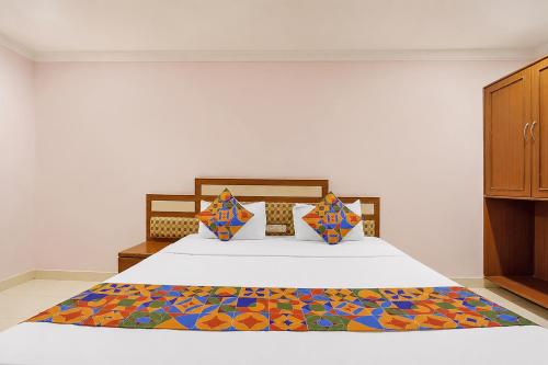 a bedroom with a bed with a colorful blanket on it at FabHotel Vaishanvi Palace in Hyderabad