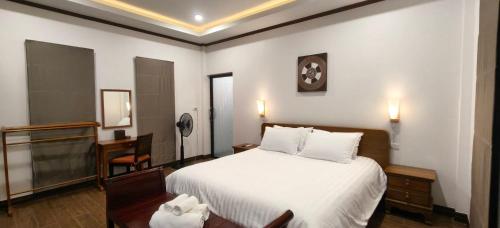 a bedroom with a bed and a clock on the wall at Ladda Garden Home in Klong Muang Beach
