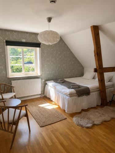 a bedroom with a bed and a table and a window at Vånga 771 in Örkelsö