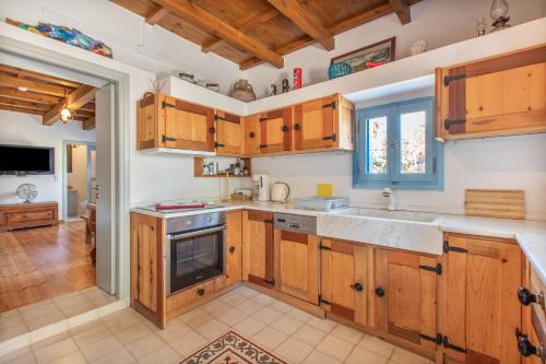 a kitchen with wooden cabinets and a sink at Villa Antonia in Almyrida