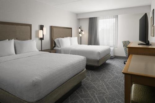 a hotel room with two beds and a flat screen tv at Hampton Inn & Suites Tilton in Tilton