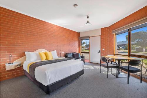 a bedroom with a bed and a brick wall at Comfort Inn Lady Augusta in Swan Hill