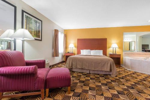 a hotel room with a bed and a bath tub at Quality Inn Sycamore - DeKalb in Sycamore