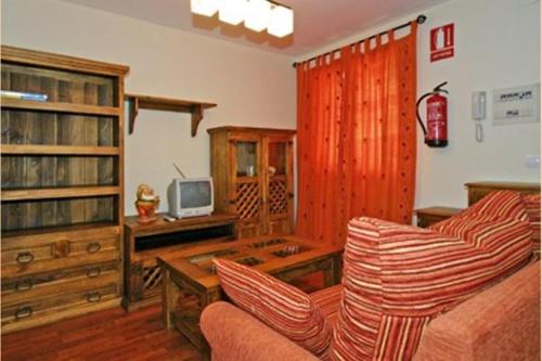 a living room with a couch and a tv at Apartamentos Rurales Les Mestes in Tazones
