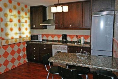 a kitchen with wooden cabinets and a counter top at Apartamentos Rurales Les Mestes in Tazones