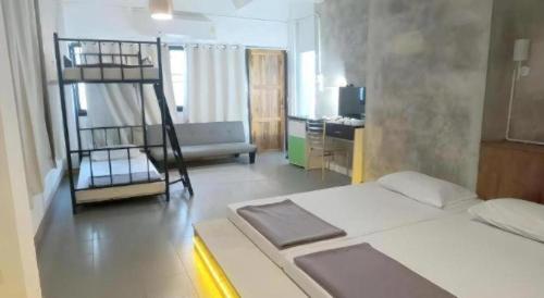 a bedroom with a bunk bed and a kitchen at Chinawat Hotel in Sukhothai
