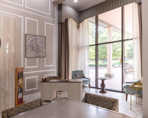 a living room with a desk and a large window at Quality Inn & Suites in Williamsburg