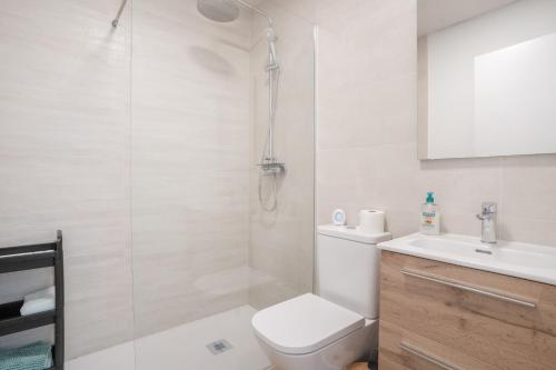 a bathroom with a toilet and a sink and a shower at Adhara lll in Torre del Mar