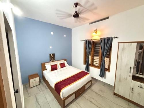 a bedroom with a bed and a ceiling fan at Zak Holidays Wayanad in Wayanad