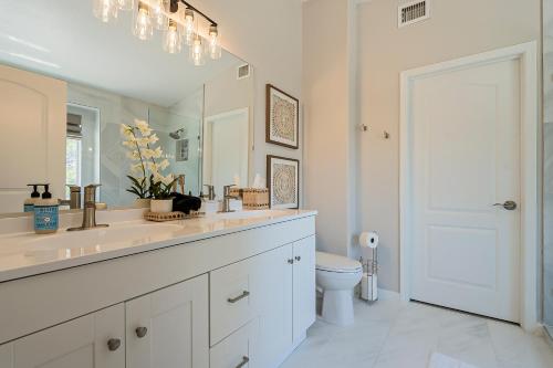 a bathroom with a sink and a toilet and a mirror at Dos Palmas - Gilbert Poolside Retreat in Gilbert