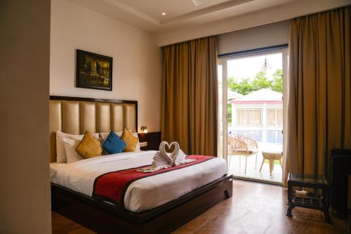 a bedroom with a large bed and a sliding glass door at Mannat Resort Paota in Prāgpura