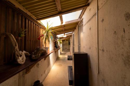 an empty hallway of a building with plants on a shelf at 海の家 in Kumejima