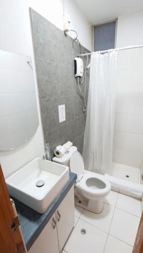 a bathroom with a white toilet and a sink at Nutria Apt in Cerro Azul with access & ocean view in Cerro Azul