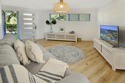 a living room with a couch and a flat screen tv at Advance Place in Sunrise Beach
