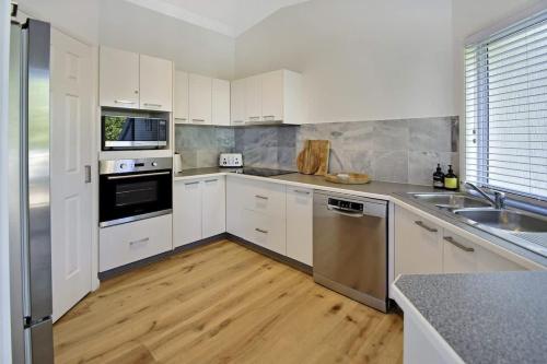 a kitchen with white cabinets and stainless steel appliances at Advance Place in Sunrise Beach