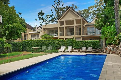 a house with a swimming pool in front of a house at Alderly Terrace in Noosa Heads