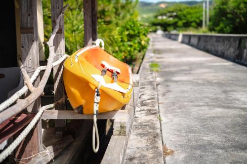 an orange suitcase sitting on the side of a building at 海の家 in Kumejima
