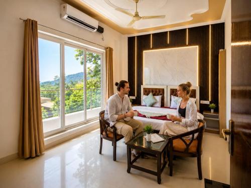 a man and woman sitting on a couch in a living room at Mountain View Retreat in Yog Tapovan in Rishīkesh