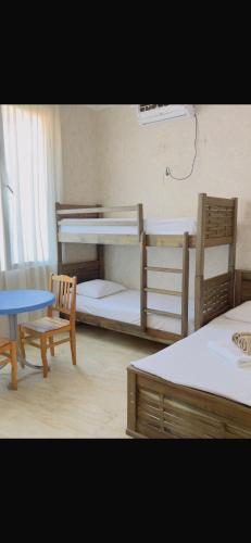 a room with two bunk beds and a table and chairs at Femyli rooms in Shekhvetili