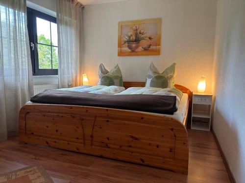 a bedroom with a large wooden bed with a window at Ferienhaus Eichenallee in Massow