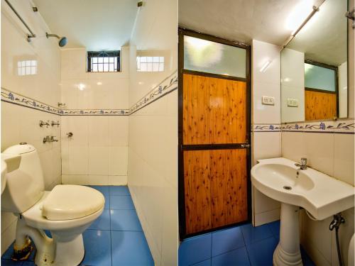 a bathroom with a toilet and a sink at Baga Wave Edge Cottages in Baga