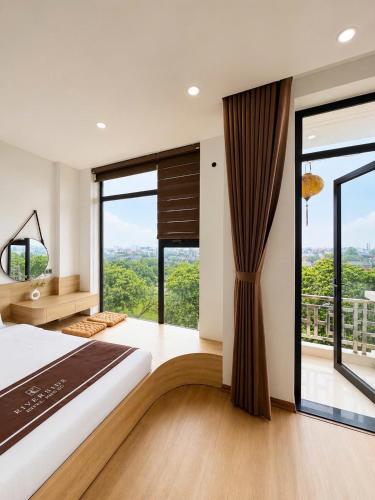 a bedroom with a large bed and large windows at Riverside Hotel in Kỳ Vĩ